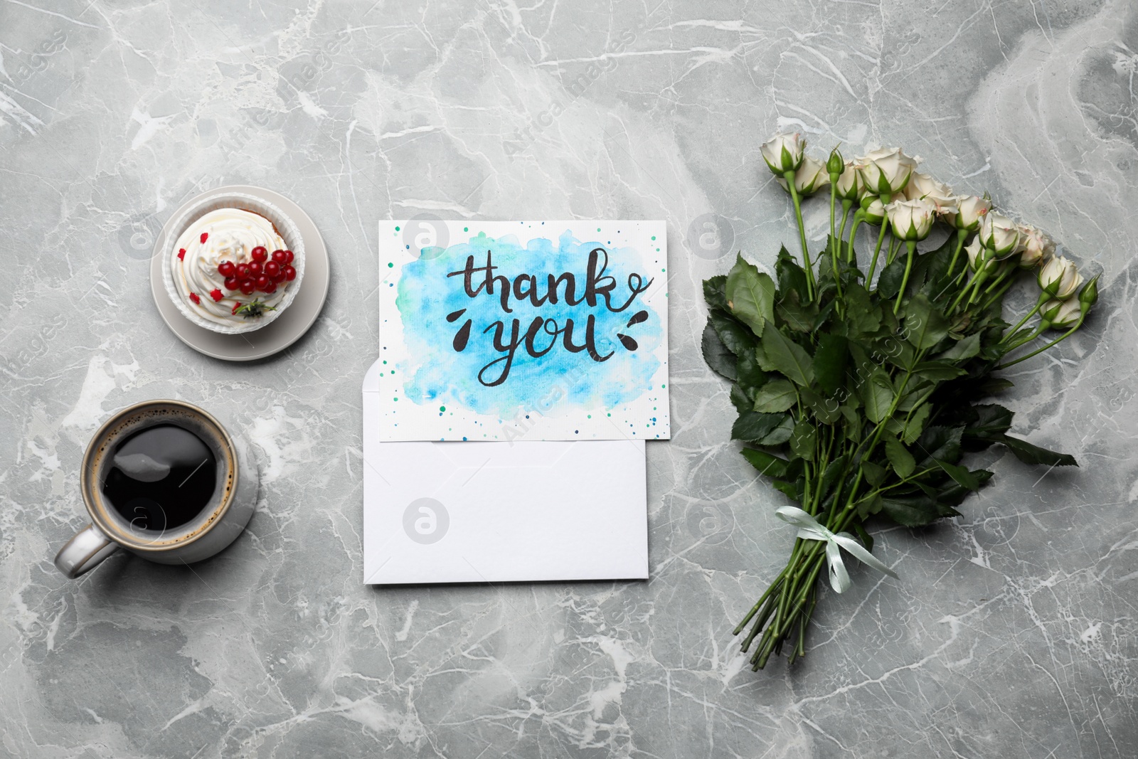 Photo of Card with phrase Thank you, cup of coffee, cupcake and flowers on light grey marble table, flat lay