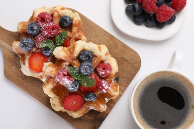 Photo of Delicious Belgian waffles with fresh berries on white table, flat lay