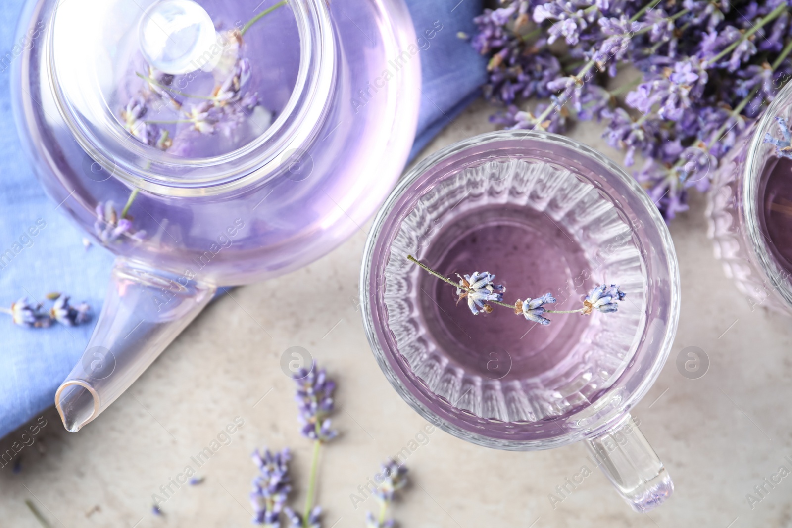 Photo of Fresh delicious drink with lavender in glass cup on grey table, flat lay