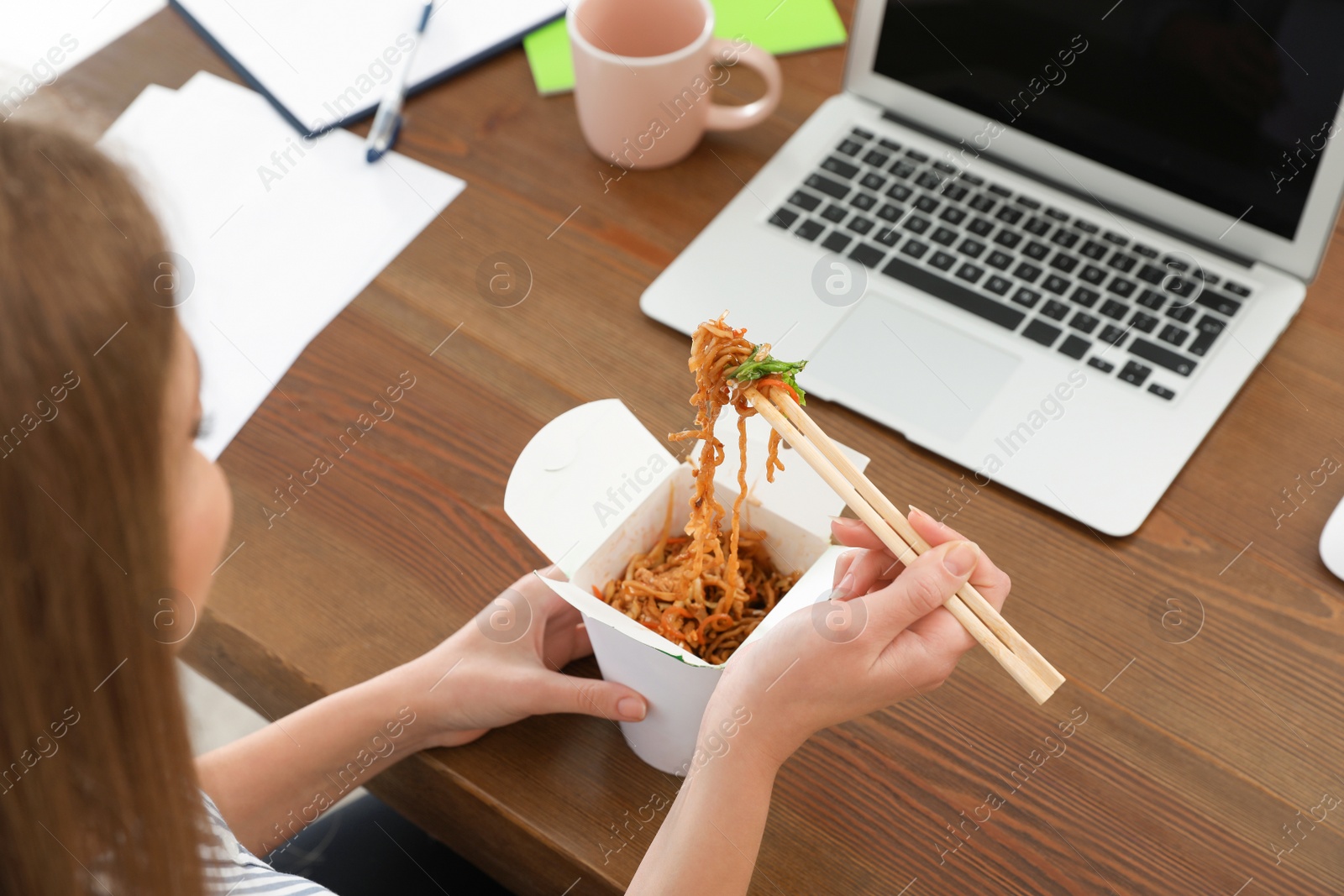 Photo of Office employee having noodles for lunch at workplace, closeup. Food delivery