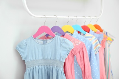 Rack with different clothes on light background, closeup