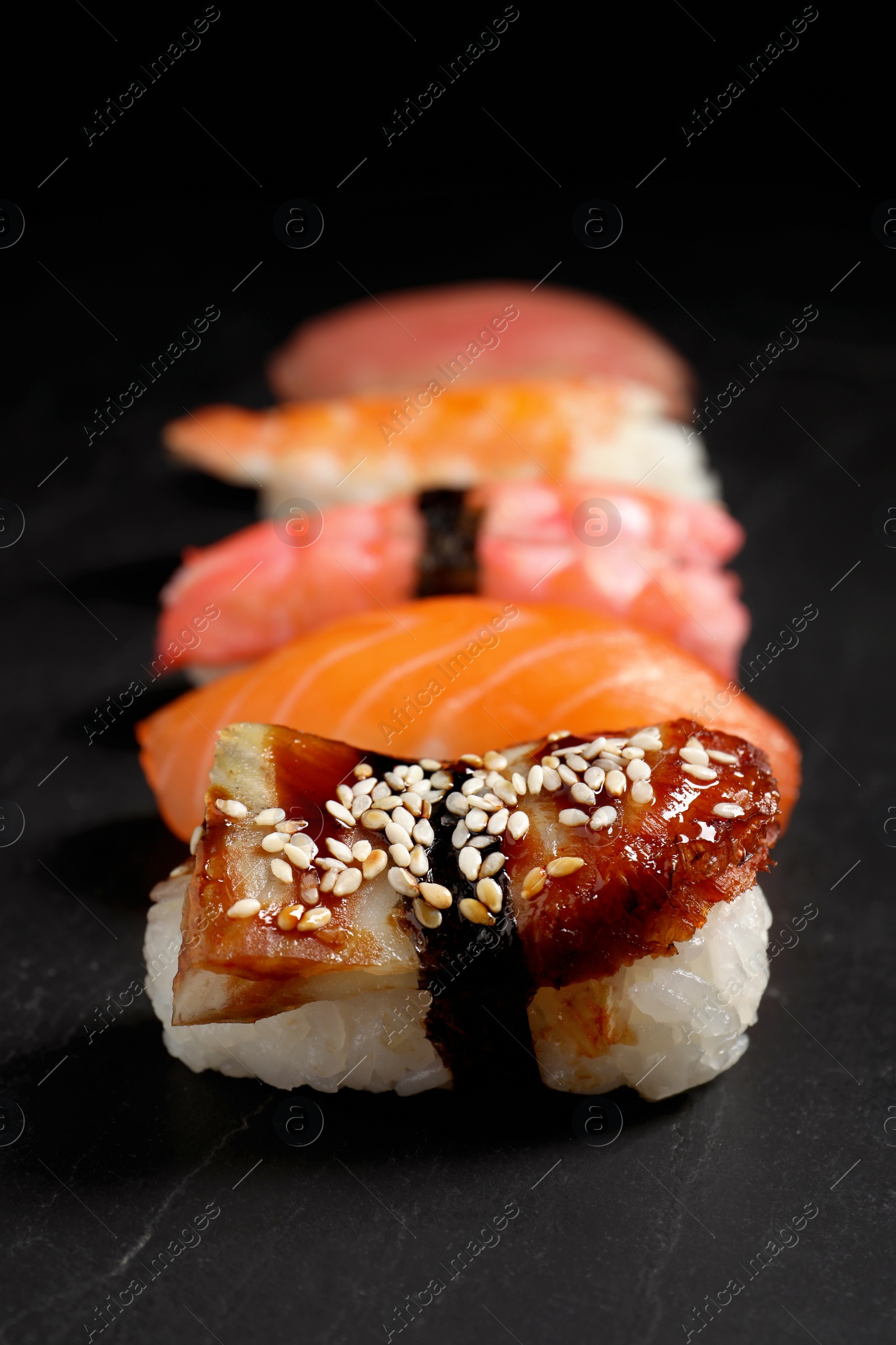 Photo of Delicious nigiri sushi on black table. Traditional Japanese cuisine
