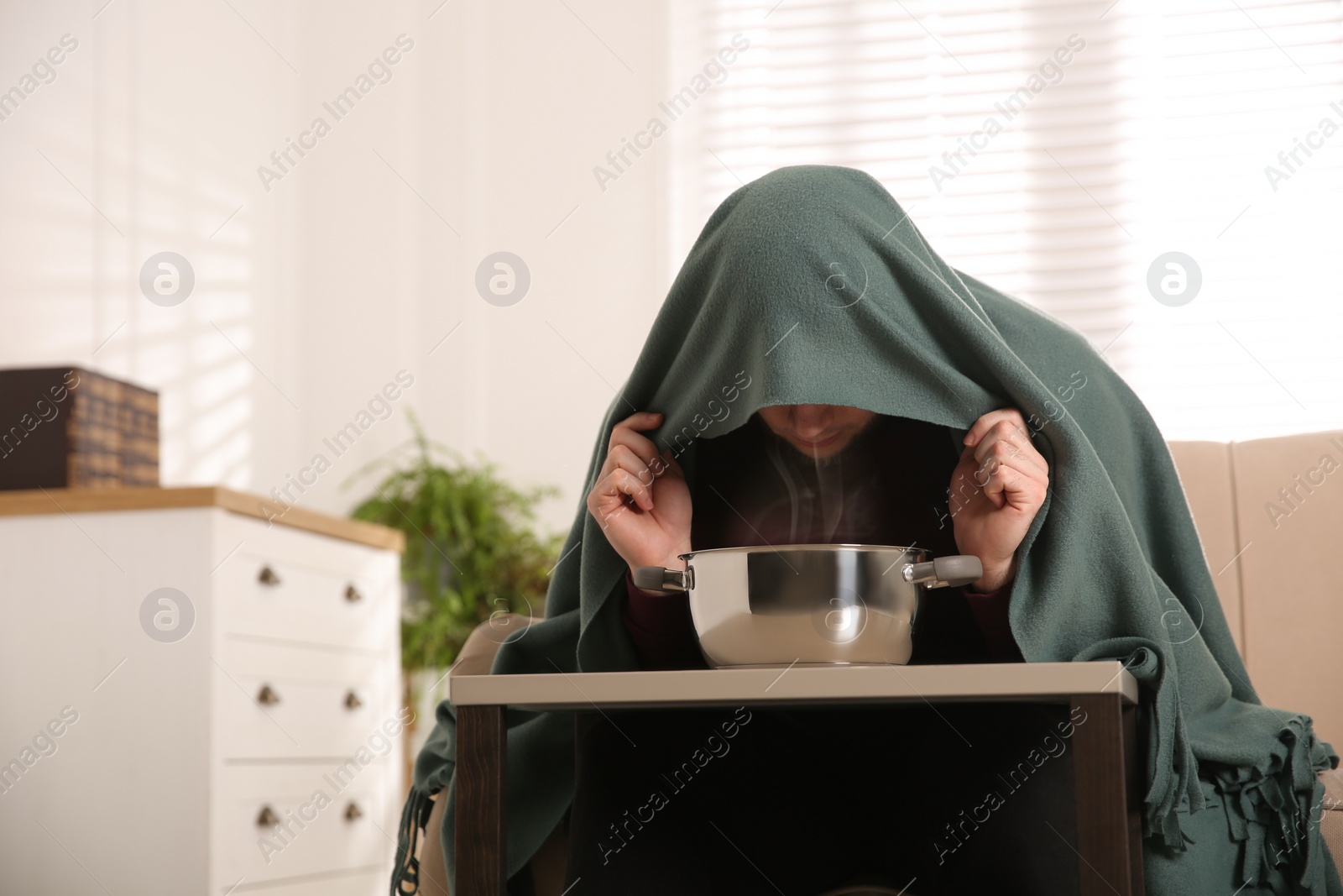 Photo of Man with plaid doing inhalation at table indoors