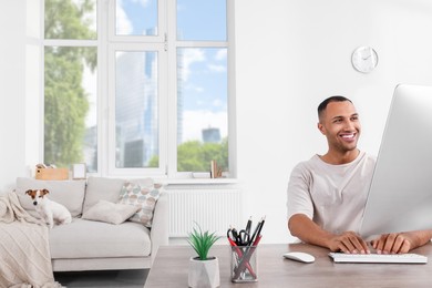 Young man with Jack Russell Terrier working at home office