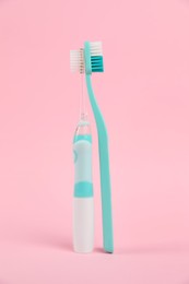 Electric and plastic toothbrushes on pink background. Dental care