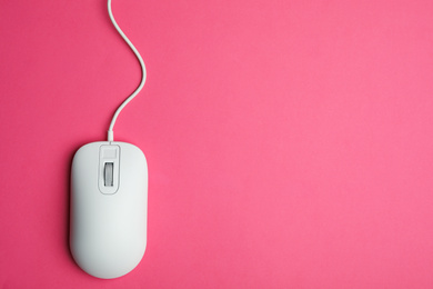 Photo of Wired computer mouse on pink background, top view. Space for text