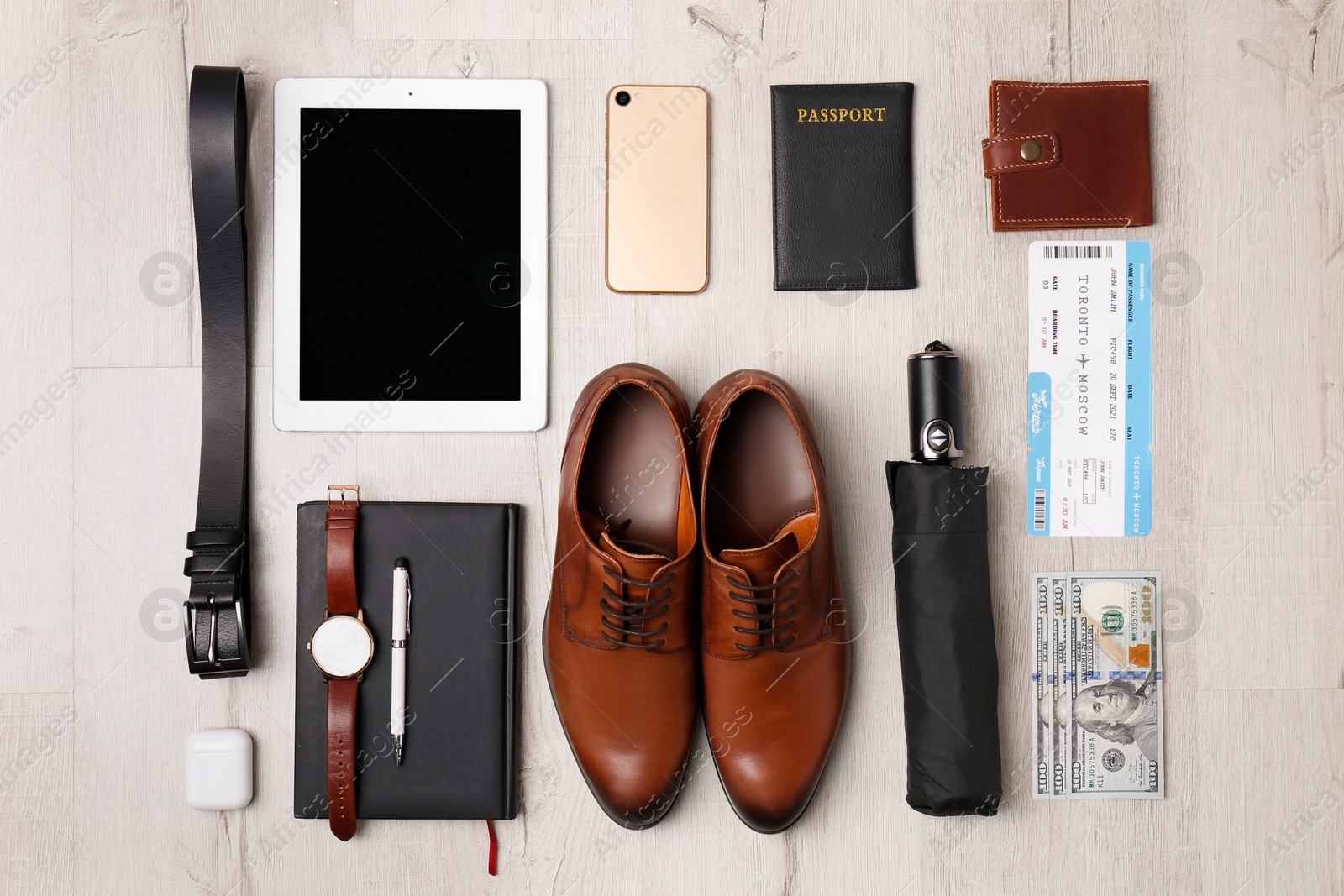 Photo of Business trip stuff on light wooden surface, flat lay