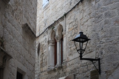 Photo of Beautiful old building with stone wall, windows and lantern