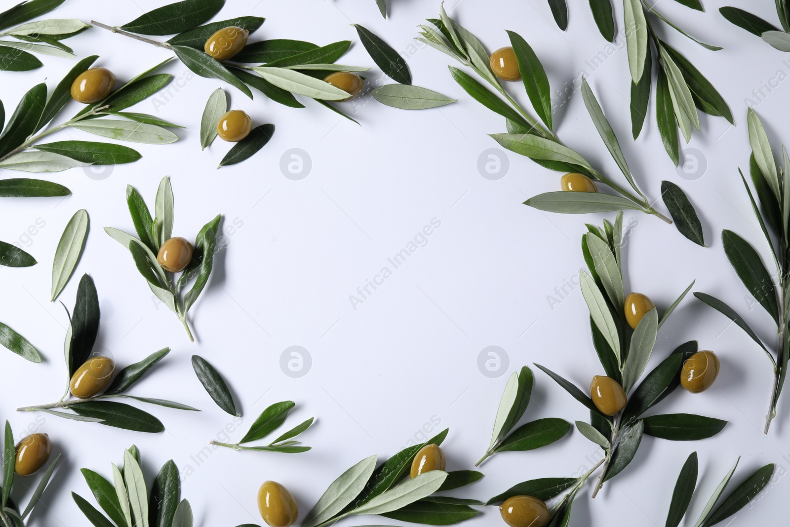 Photo of Frame made of fresh green olives and leaves on white background, flat lay. Space for text