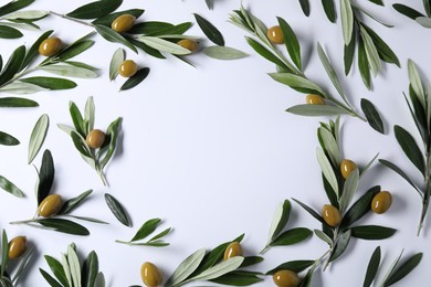 Photo of Frame made of fresh green olives and leaves on white background, flat lay. Space for text