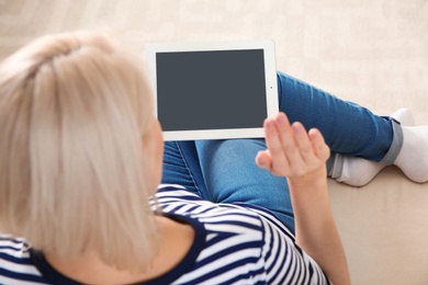 Photo of Woman using video chat on tablet at home. Space for text