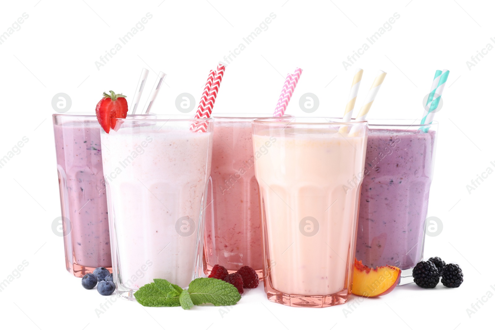 Photo of Different fresh tasty milk shakes in glasses with ingredients on white background