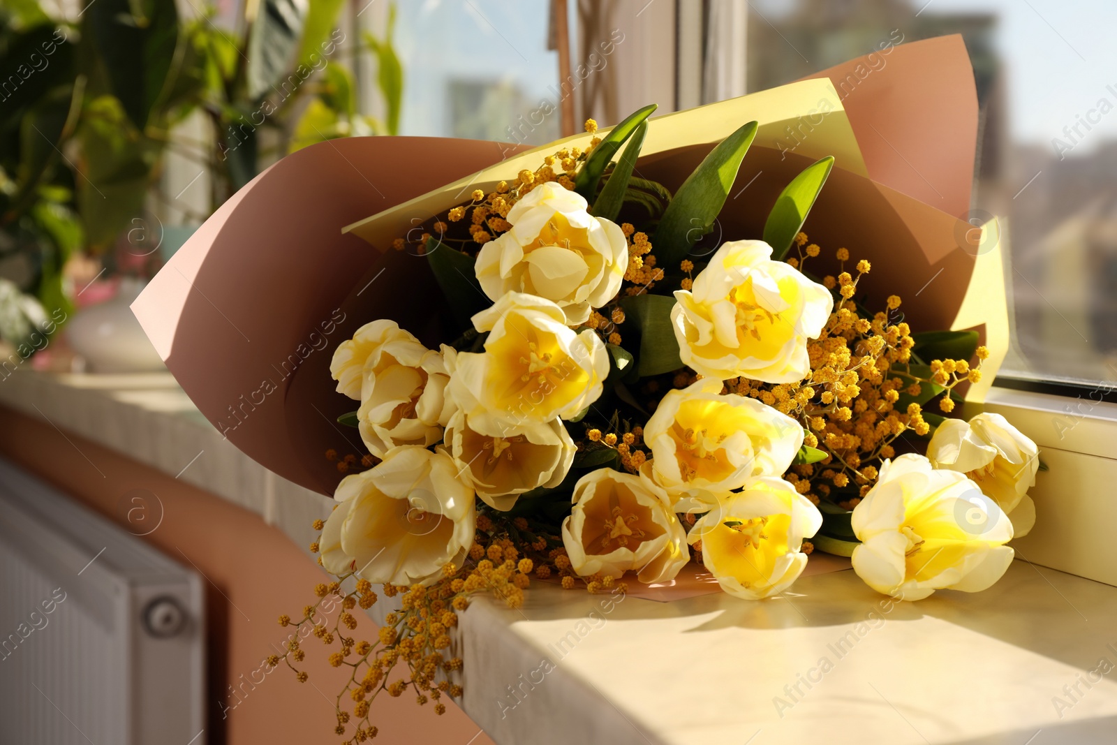 Photo of Bouquet with beautiful tulips and mimosa flowers on windowsill indoors