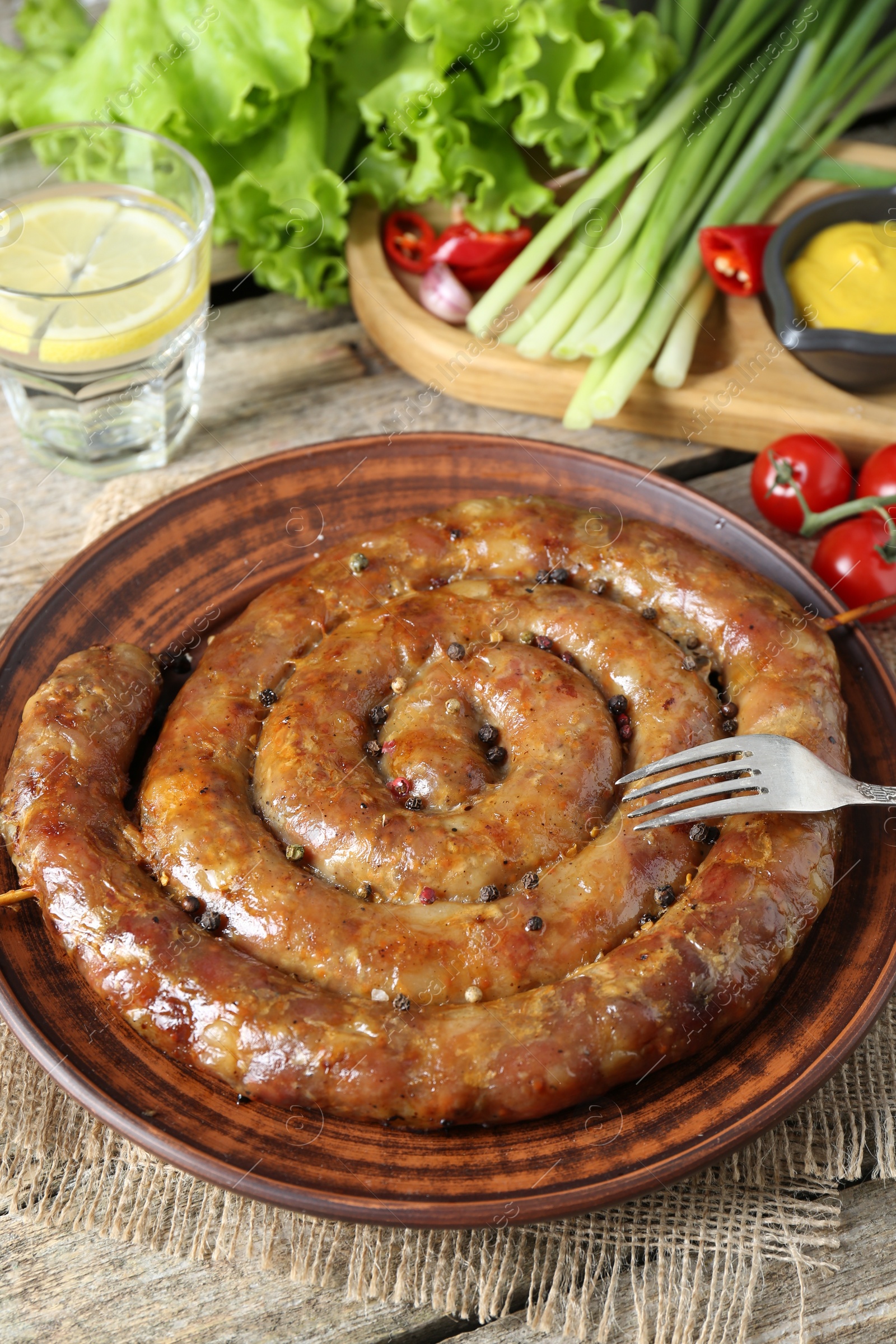 Photo of Tasty homemade sausages served on wooden table, closeup