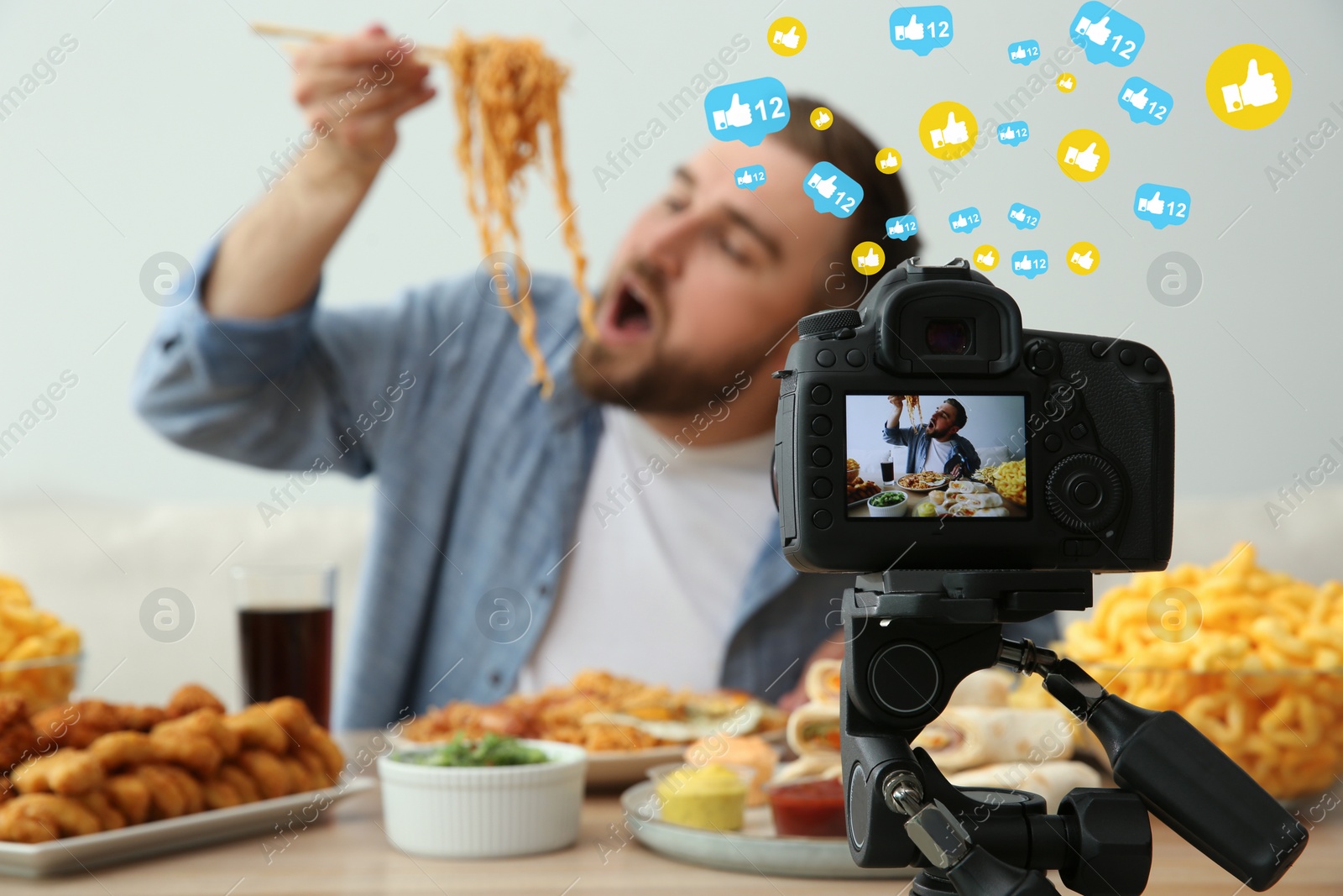 Image of Food blogger recording eating show against light background, focus on camera screen. Mukbang vlog