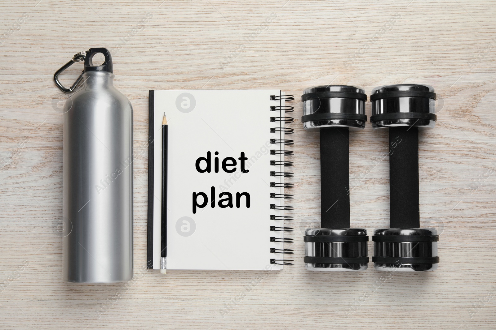 Photo of Weight loss concept. Flat lay composition with notebook, dumbbells and bottle of water on white wooden table