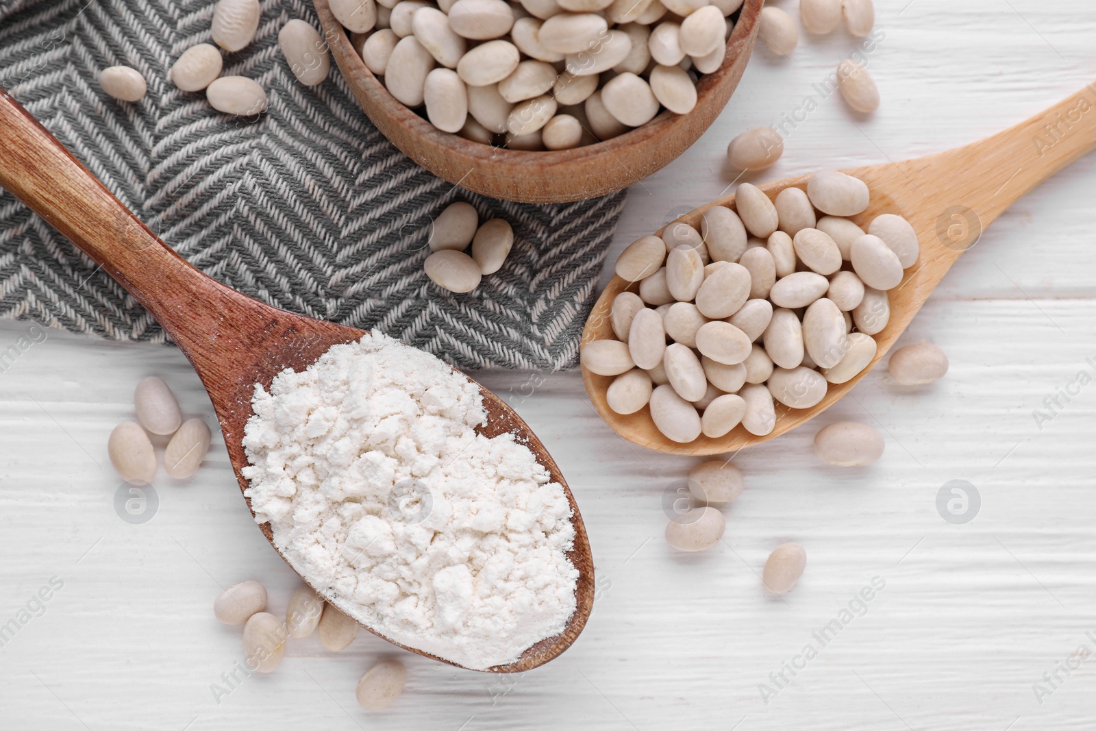 Photo of Kidney bean flour and seeds on white wooden table, flat lay