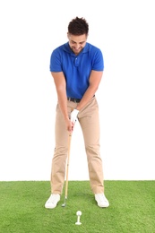 Young man playing golf on course against white background