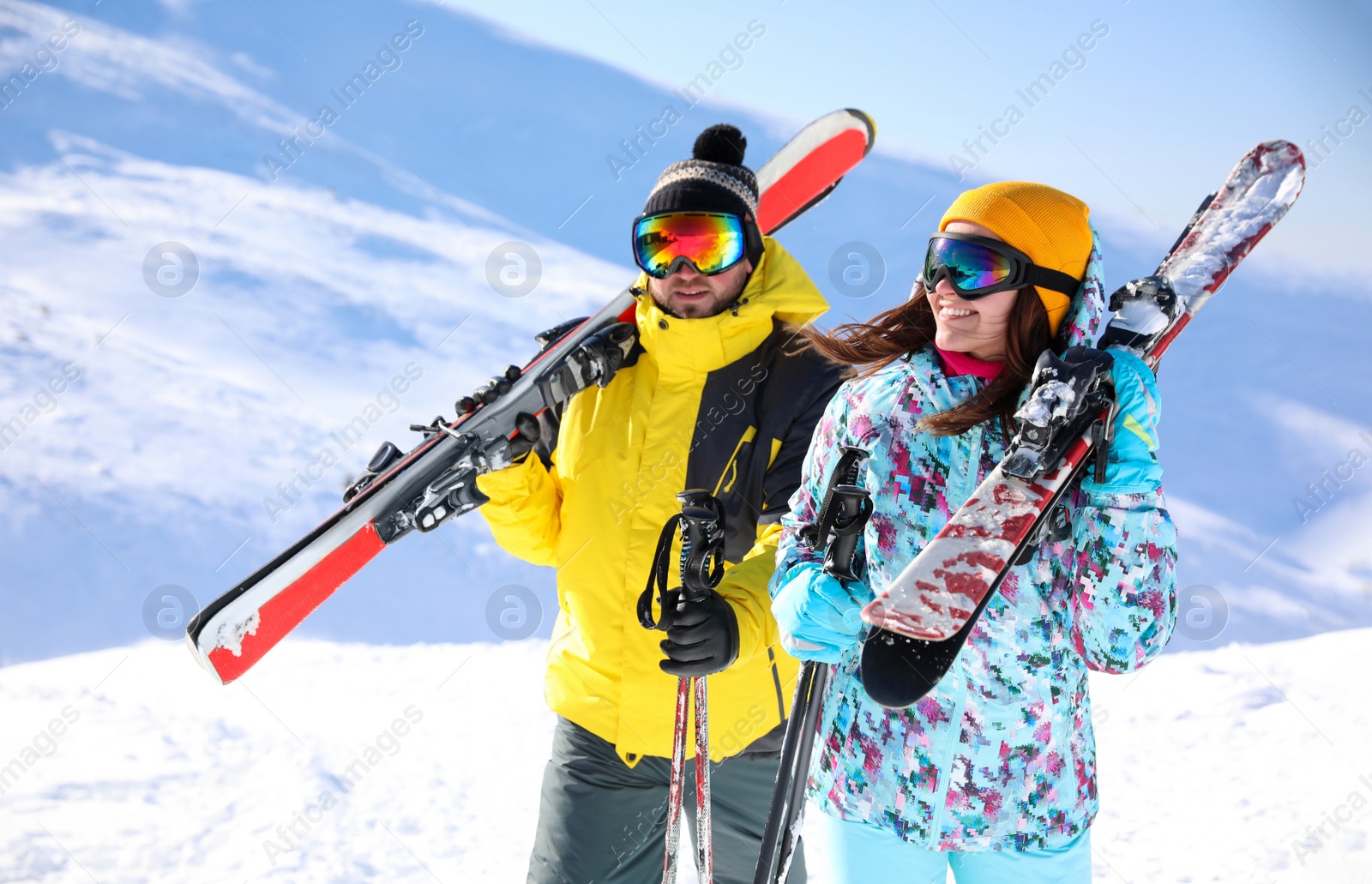 Photo of Young couple with skis on hill. Winter vacation