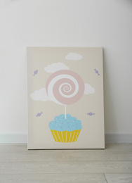 Photo of Adorable picture of cupcake and lollipop on floor near white wall. Children's room interior