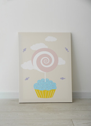 Adorable picture of cupcake and lollipop on floor near white wall. Children's room interior