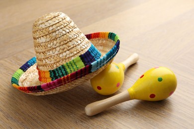 Mexican sombrero hat and maracas on wooden table