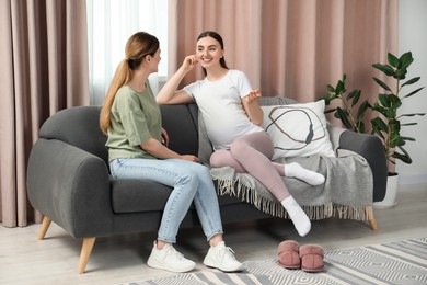 Photo of Doula working with pregnant woman on sofa at home. Preparation for child birth