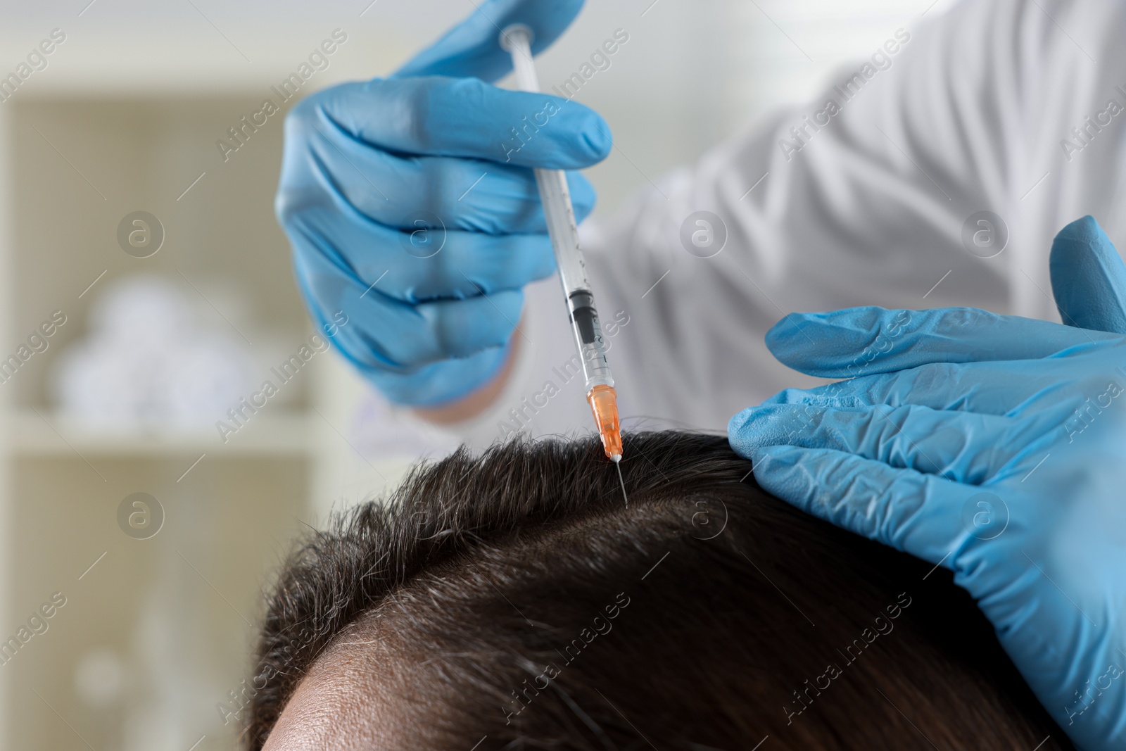 Photo of Trichologist giving injection to patient in clinic, closeup