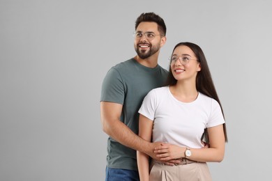 Photo of Beautiful couple wearing glasses on light gray background, space for text