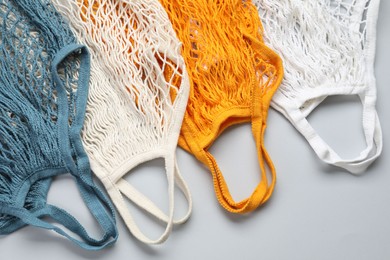 Photo of Different string bags on light grey background, top view