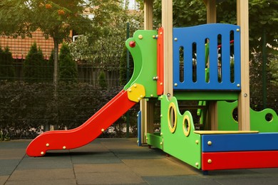 Photo of Empty outdoor children's playground with slide near fence