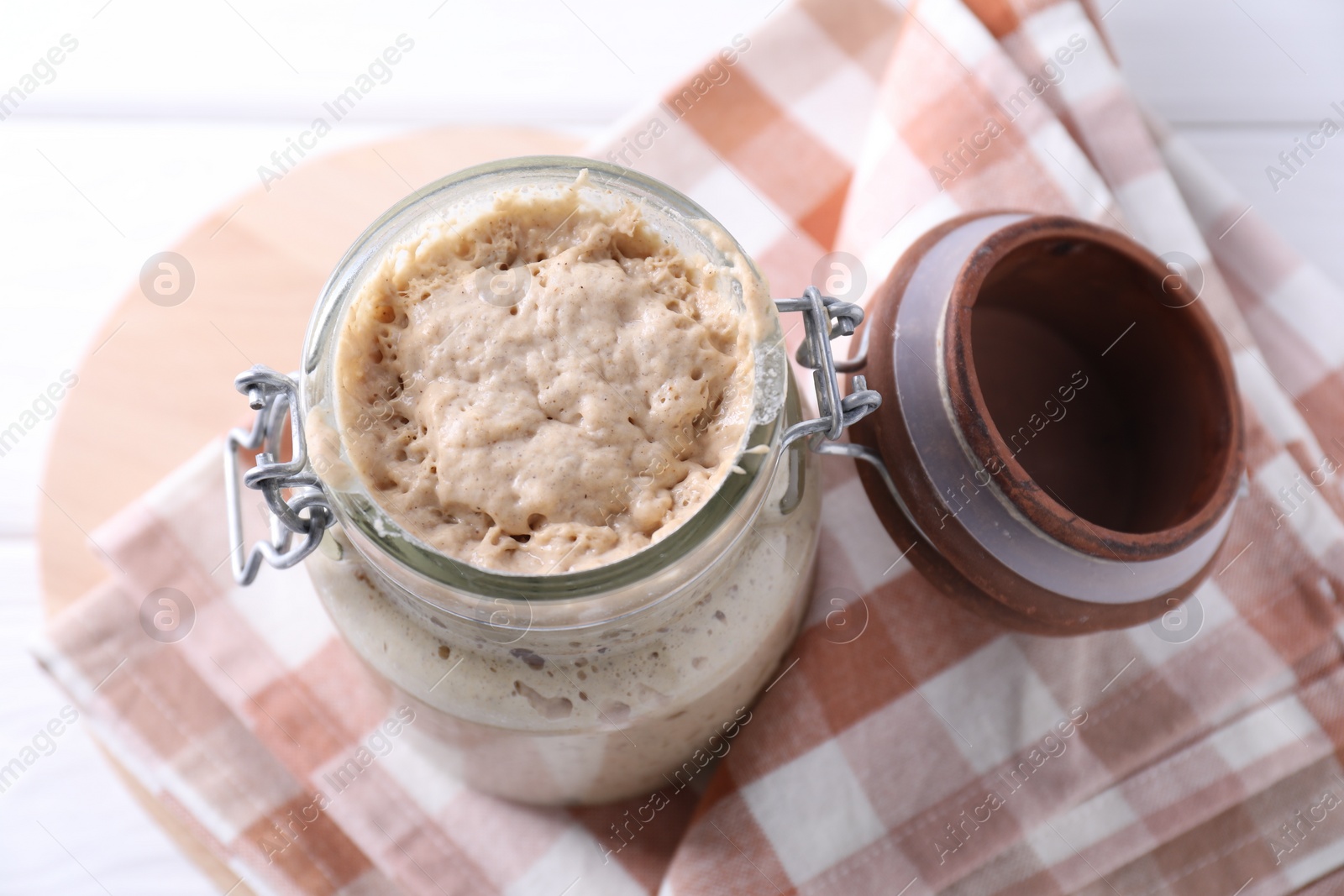 Photo of Sourdough starter in glass jar on table, above view