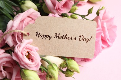 Image of Happy Mother's Day greeting label and beautiful flowers on pink background