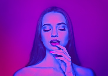 Image of Young woman with beautiful makeup posing in neon lights