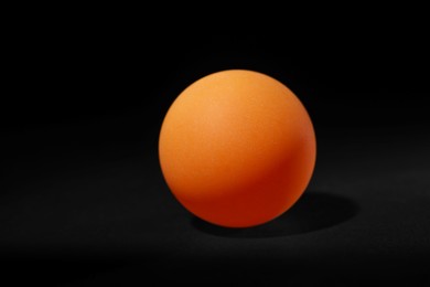 Photo of One ping pong ball on black background
