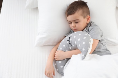 Photo of Cute little boy with toy sleeping in bed, above view. Space for text