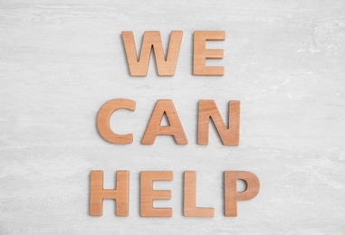 Text We Can Help made of letters on wooden background