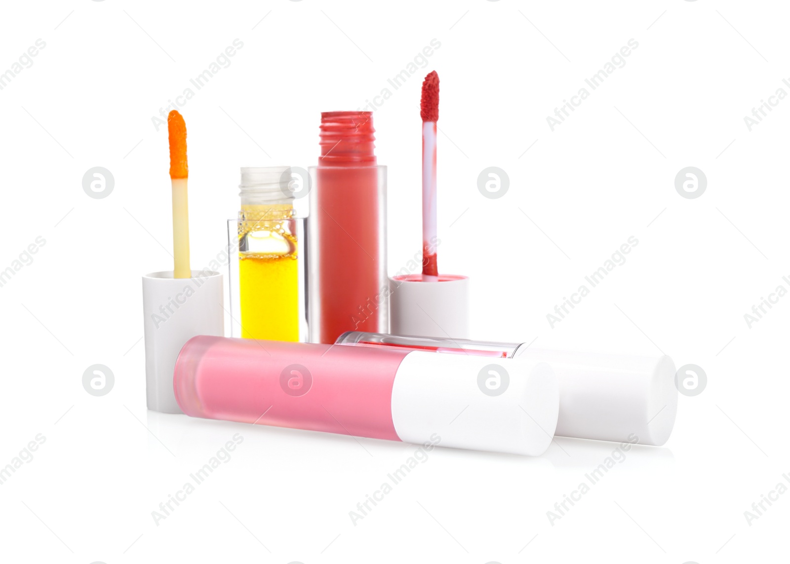 Photo of Different lip glosses and applicators isolated on white