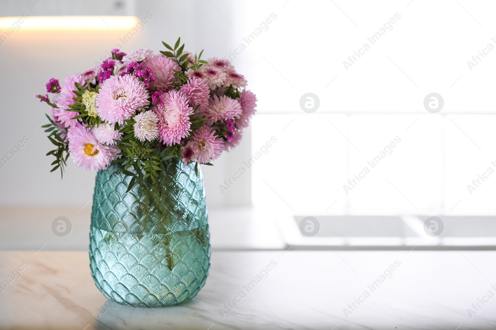 Photo of Vase with beautiful chrysanthemum flowers on table in kitchen, space for text. Interior design