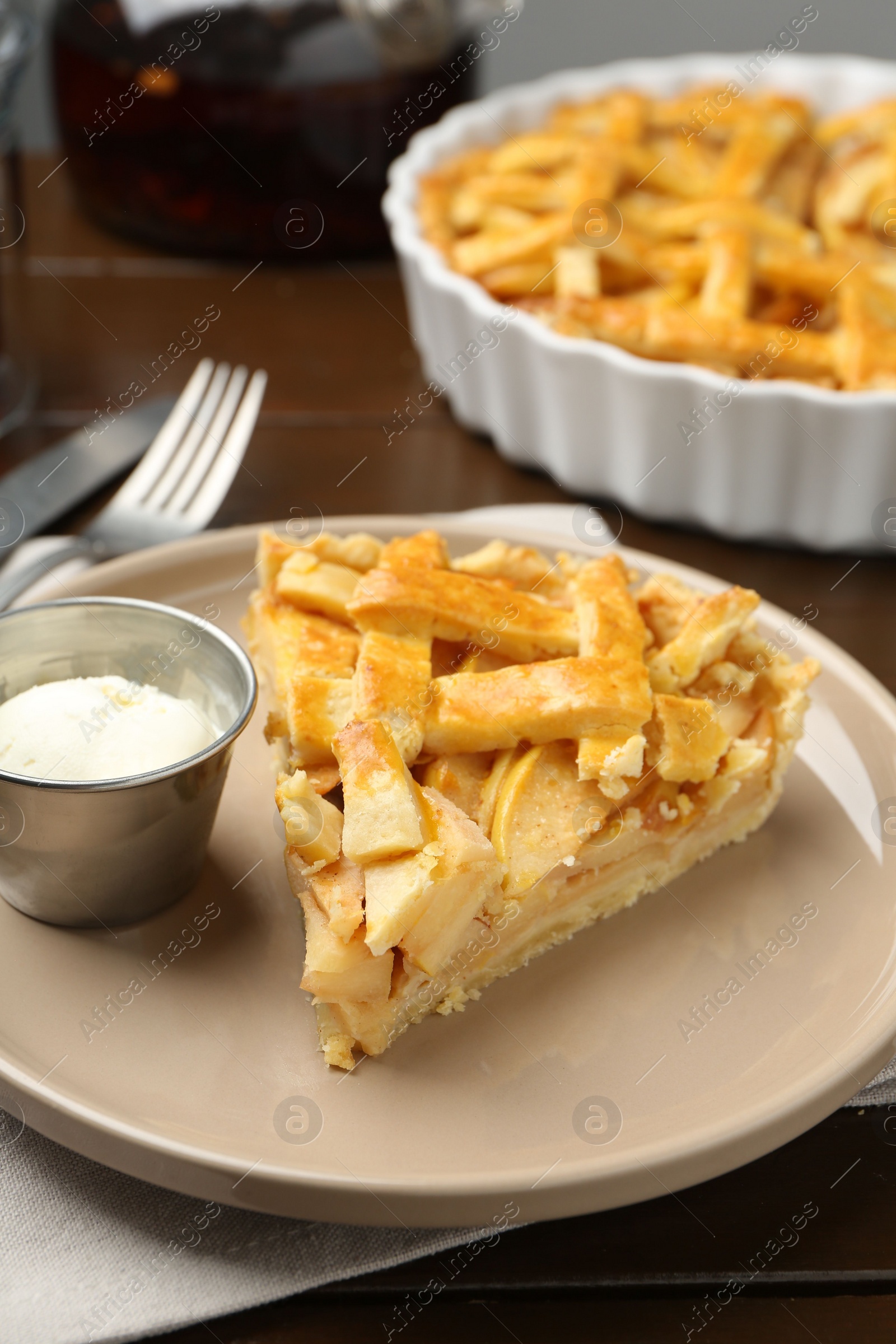 Photo of Piece of tasty homemade quince pie with ice cream on table, closeup