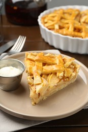 Photo of Piece of tasty homemade quince pie with ice cream on table, closeup