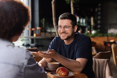 International dating. Lovely couple spending time together in cafe