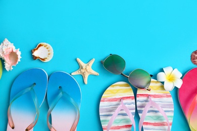 Photo of Flat lay composition with different flip flops on blue background, space for text. Summer beach accessories