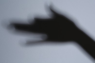 Shadow of hand like dog on grey background