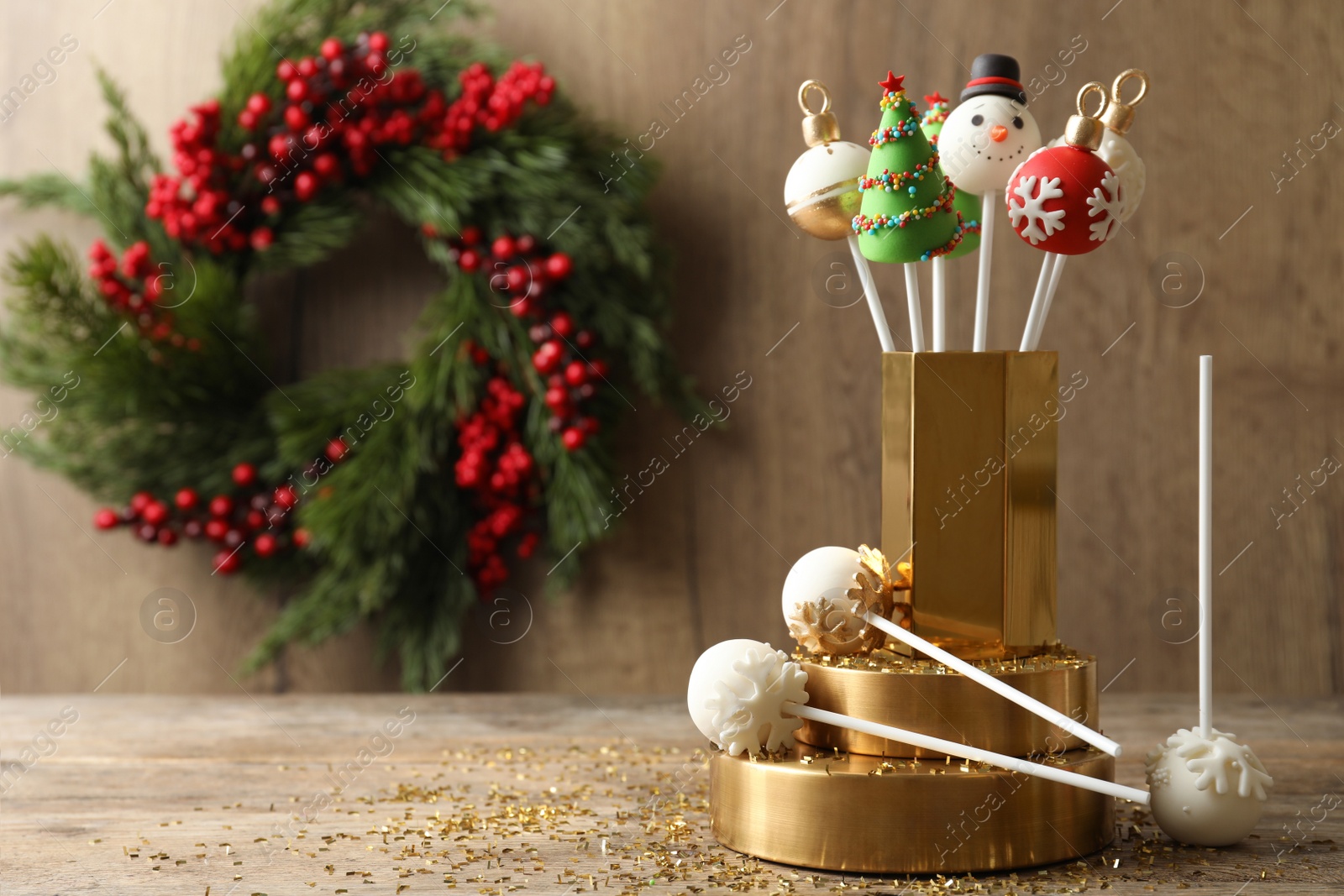 Photo of Delicious Christmas themed cake pops on wooden table. Space for text