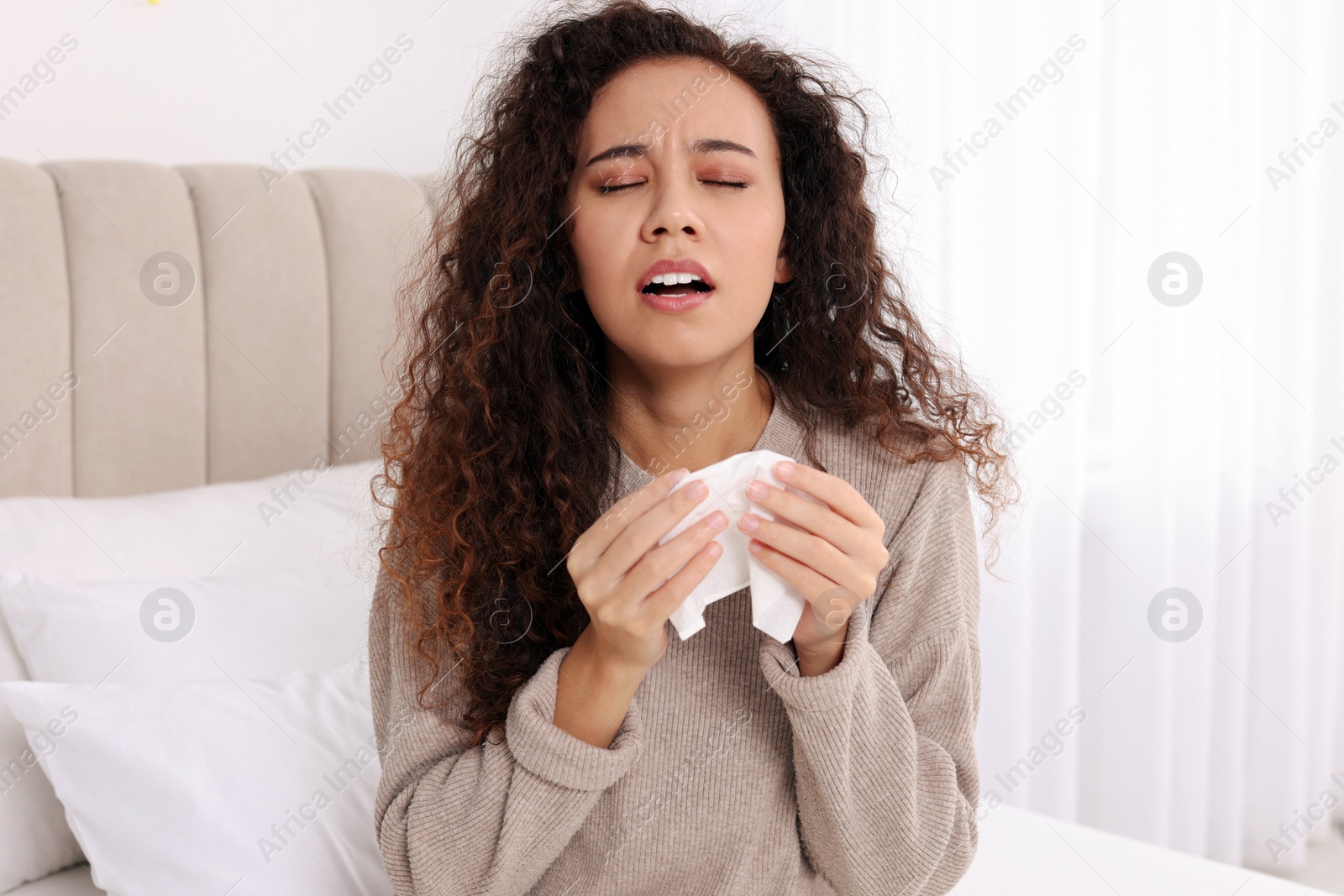 Photo of Sick African American woman with tissue in bed at home