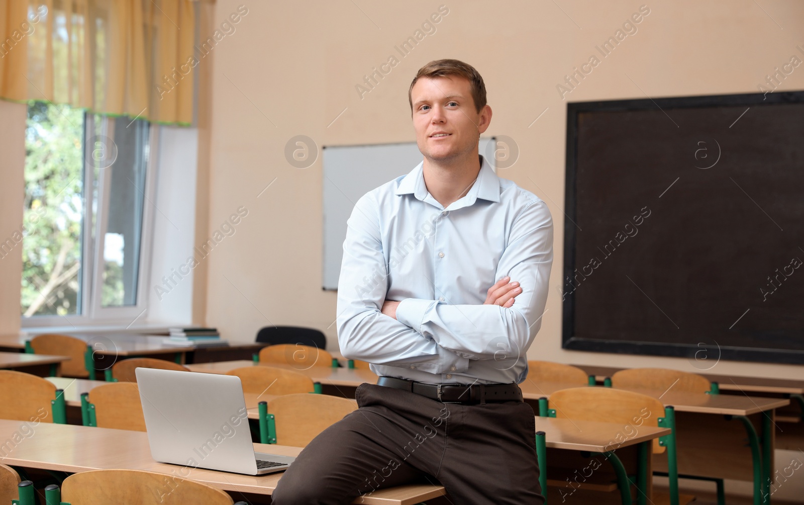 Photo of Portrait of male teacher in modern classroom