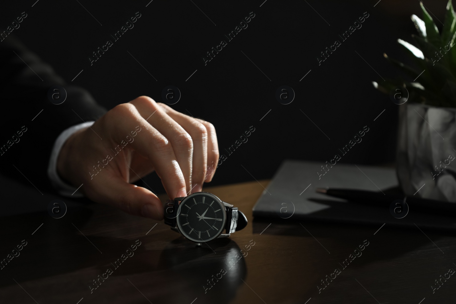 Photo of Man putting luxury wrist watch on table, closeup. Space for text