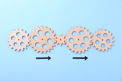 Business process organization and optimization. Scheme with wooden figures and arrows on light blue background, top view