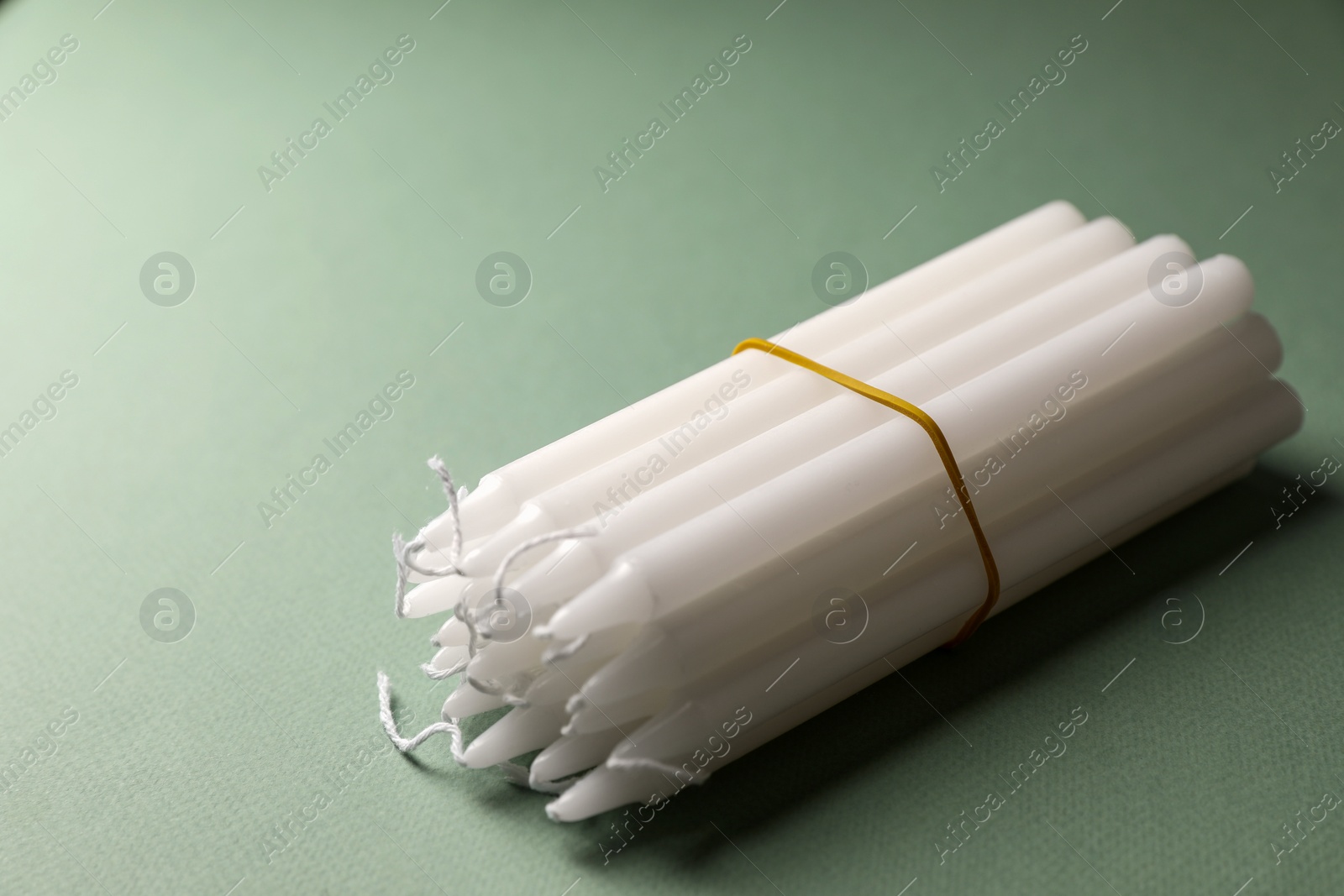 Photo of Many church wax candles on olive background. Space for text